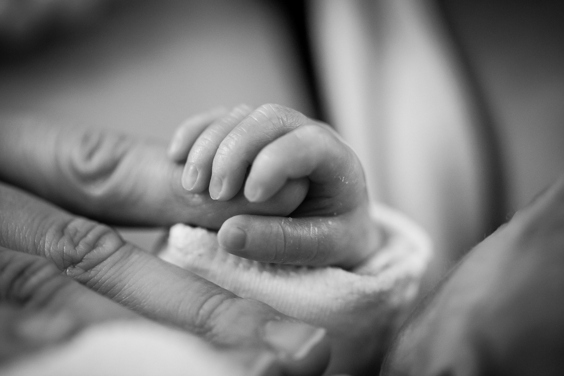 A baby holding a parents finger