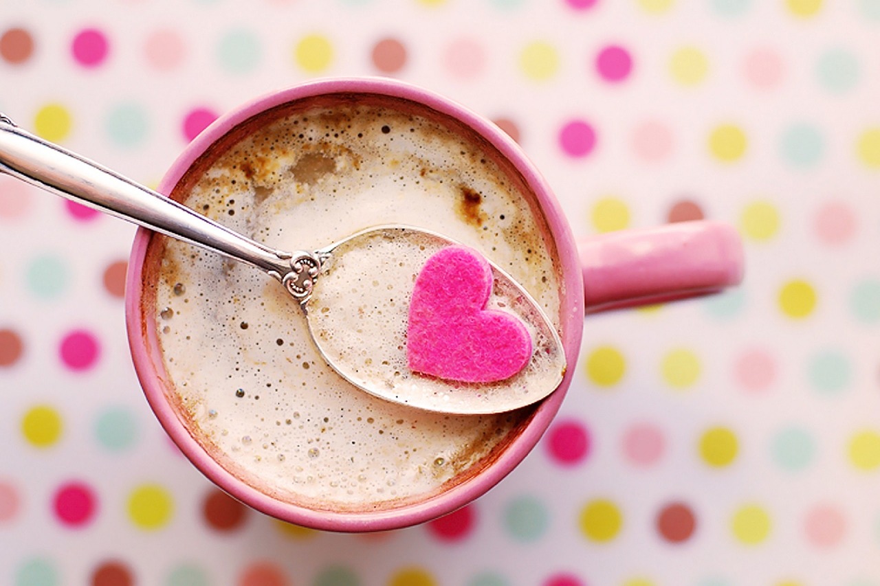 A cup of coffee with a pink heart