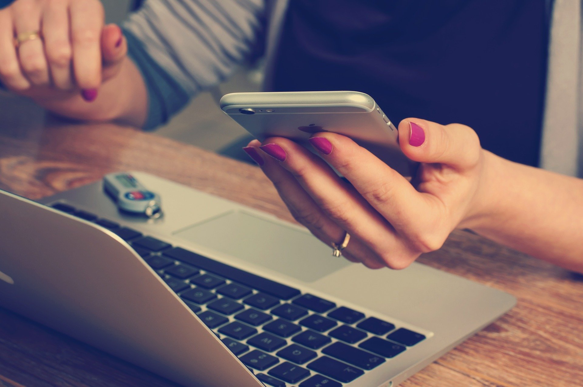 A woman with a phone and laptap that is going back to work after maternity leave