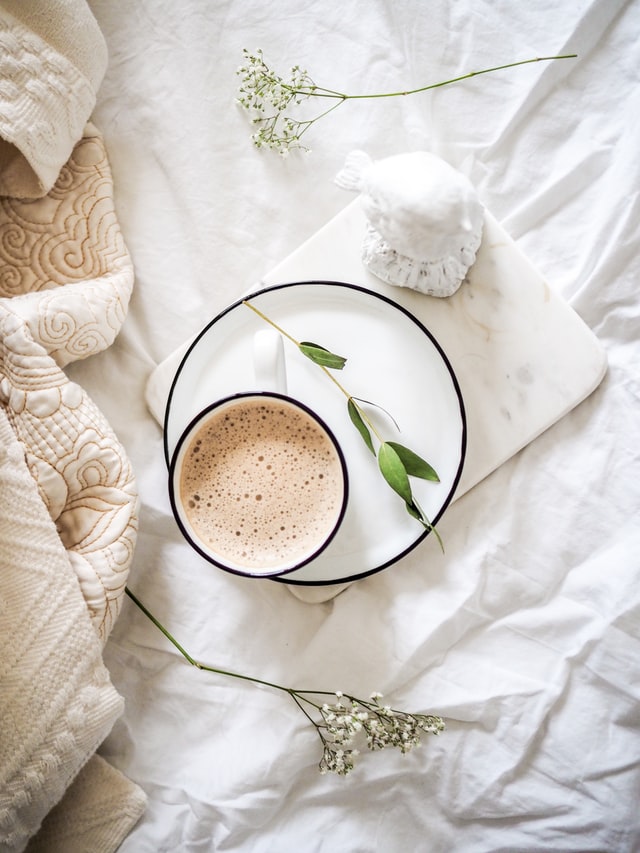 A cup of coffee on a bed