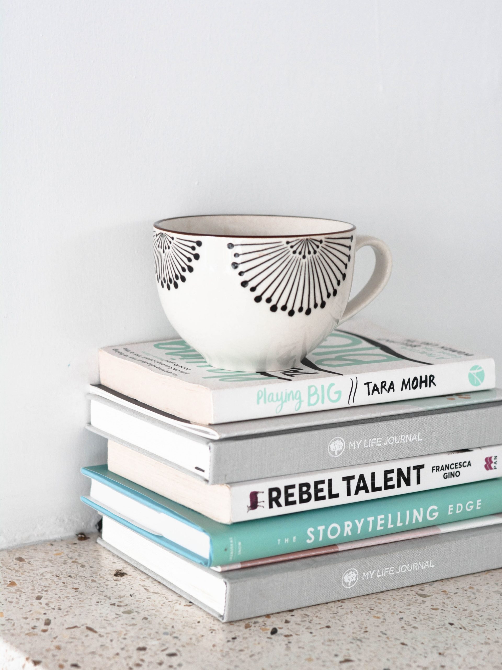 A stack of books and a coffee mug